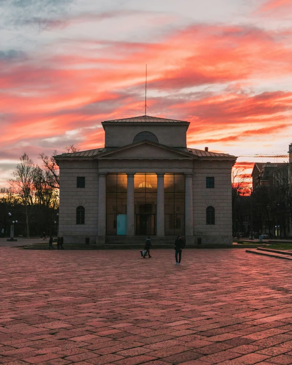 a stone structure sitting in a courtyard under a red sky