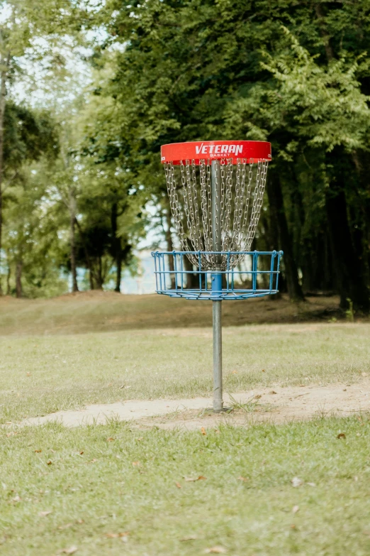 a frisbee golf basket with trees in the background