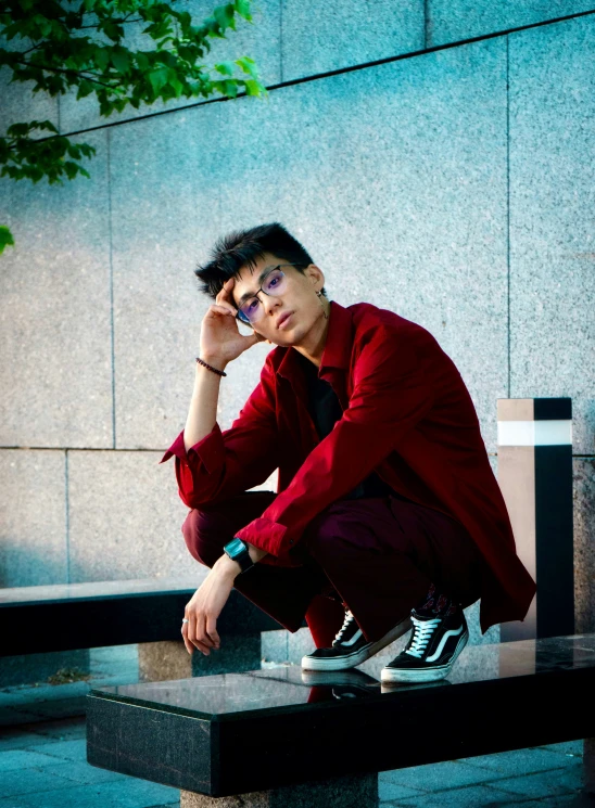 a man sitting on a concrete table, holding his head in one hand