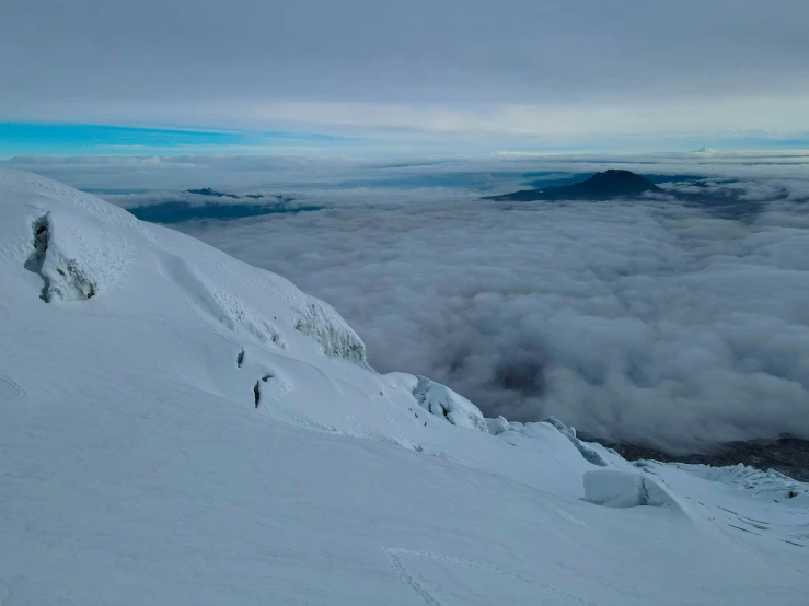 skiers standing at the top of a snow covered hill