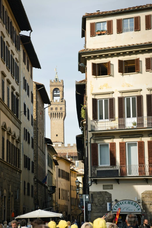 many people walking down a street with buildings on either side