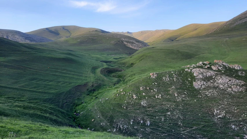 mountains with grass and rocks on them are shown