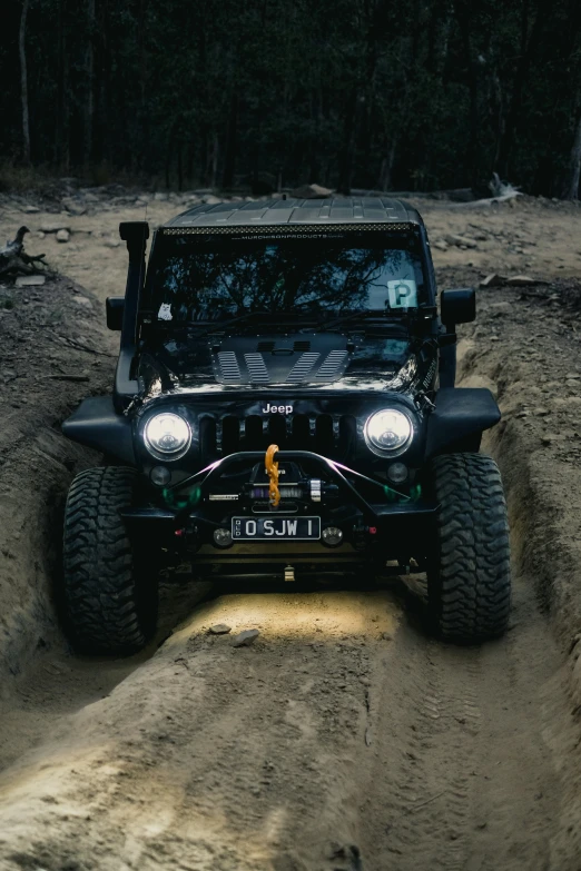 the jeep is on a dusty road driving through a field