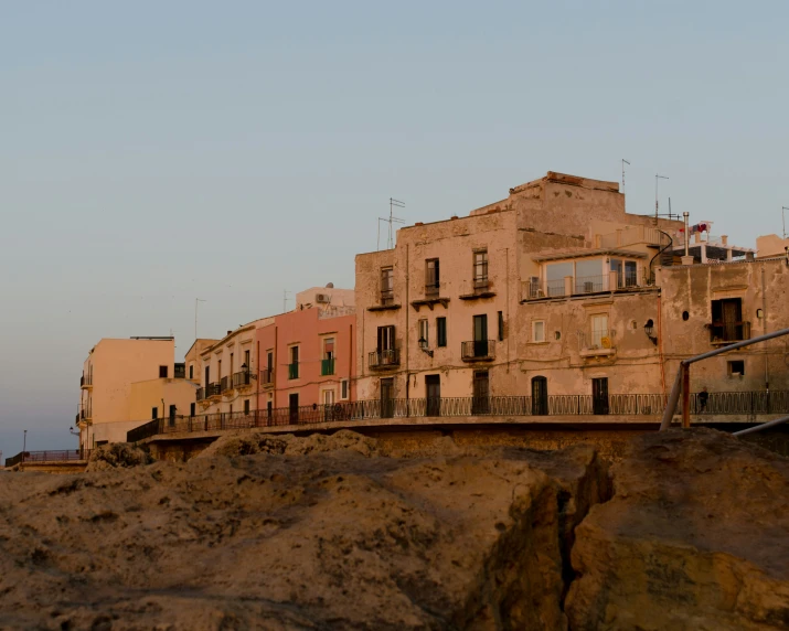 an old town sits at the edge of the cliff with a lighthouse on top