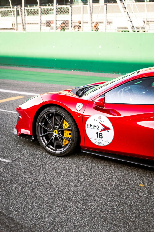 a red sports car with an extreme painted stripe is on a race track