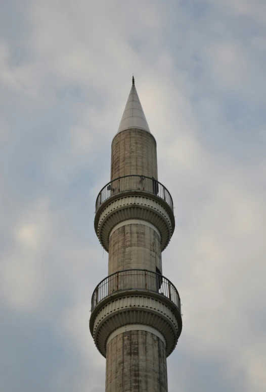 a tall tower has a balcony next to it