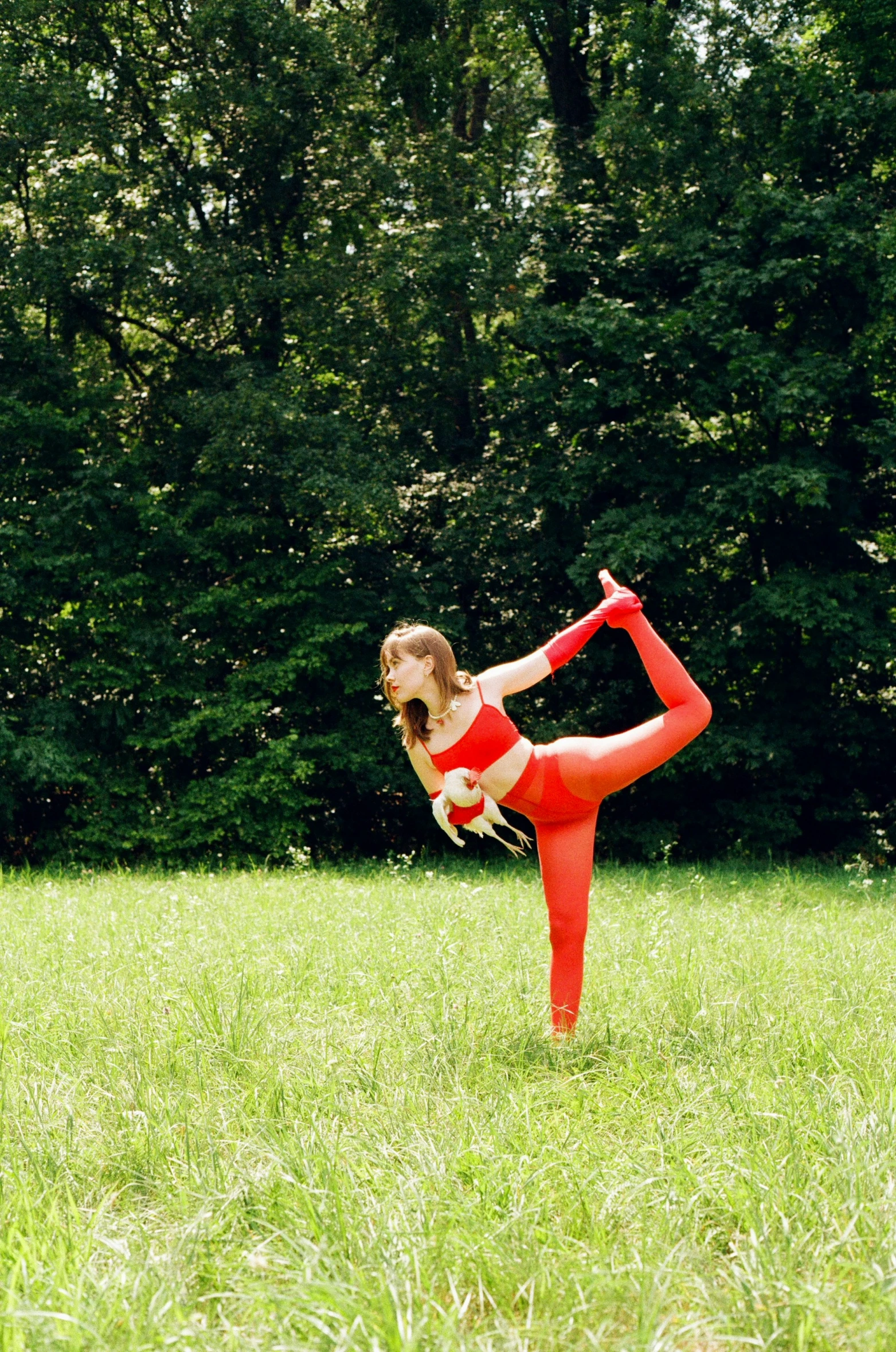 a girl in a bikini doing yoga in a field