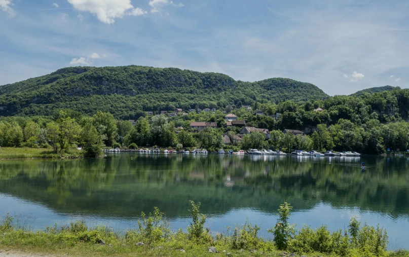 a beautiful mountain valley overlooks a lake filled with boats