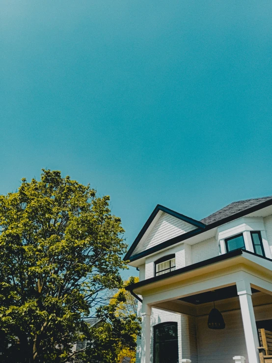 a big white house sitting on top of a lush green hillside