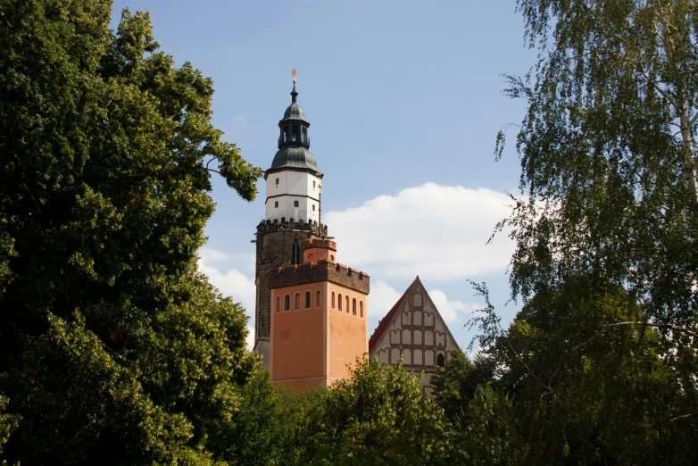 an old tower with steeples and two towers in the background