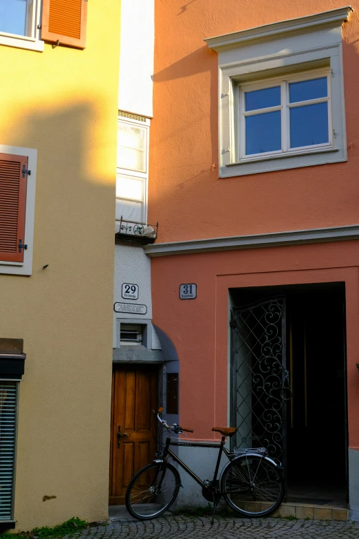 bicycle leaning against an orange and yellow building