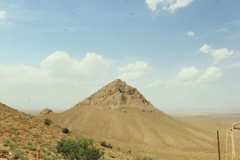 a giraffe stands on top of a hill and looks into the distance