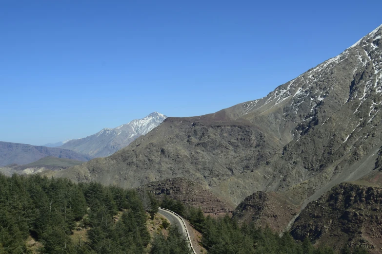 the view from the top of the mountain shows the view of the road in front of the snow covered mountains