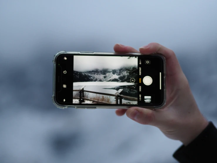 a man holding a phone taking a picture