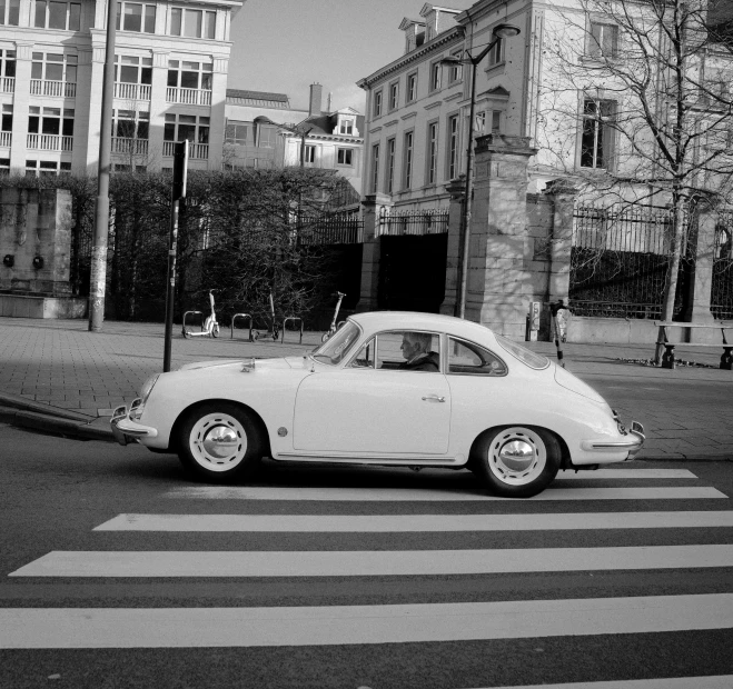 black and white image of an old car in the street