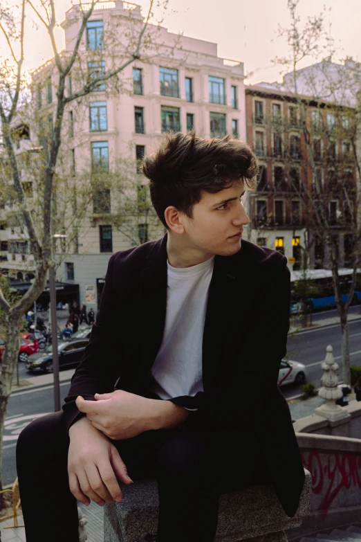 a man sitting on a bench in front of a city building