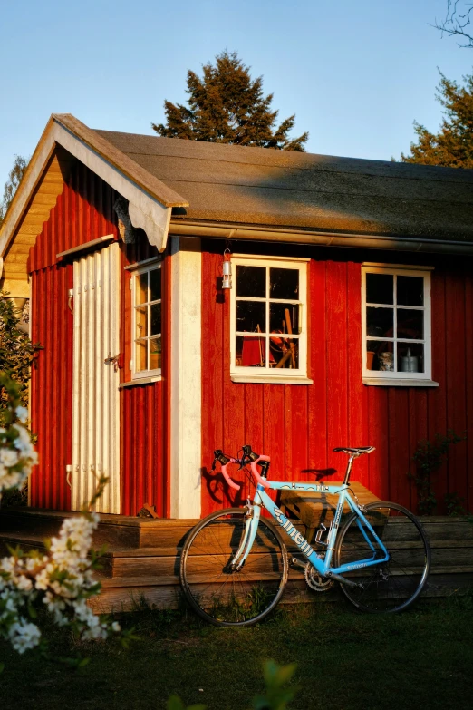 two bikes are parked outside of a red shed