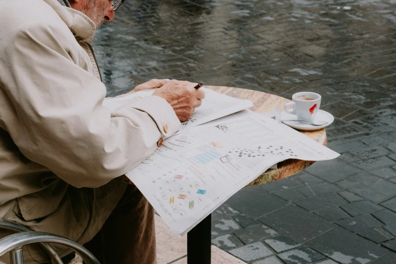 an old man writing on his paper with his hand