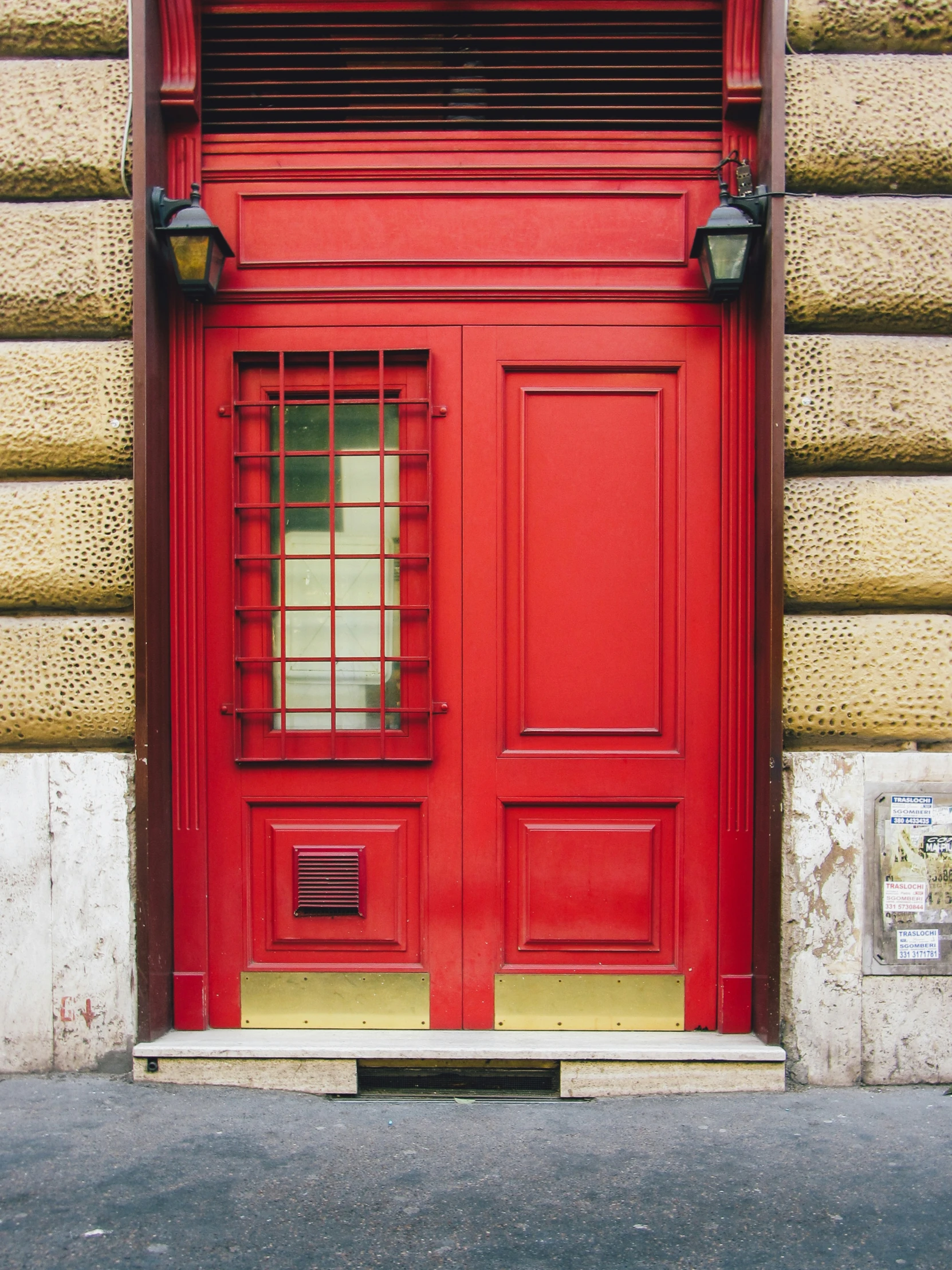 a red door with two windows sitting under a window