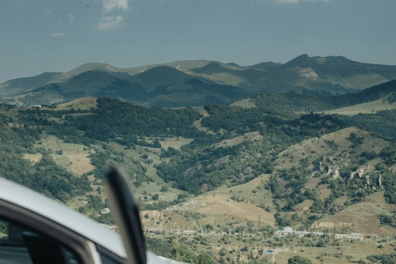 car with its side mirror facing down at the mountains