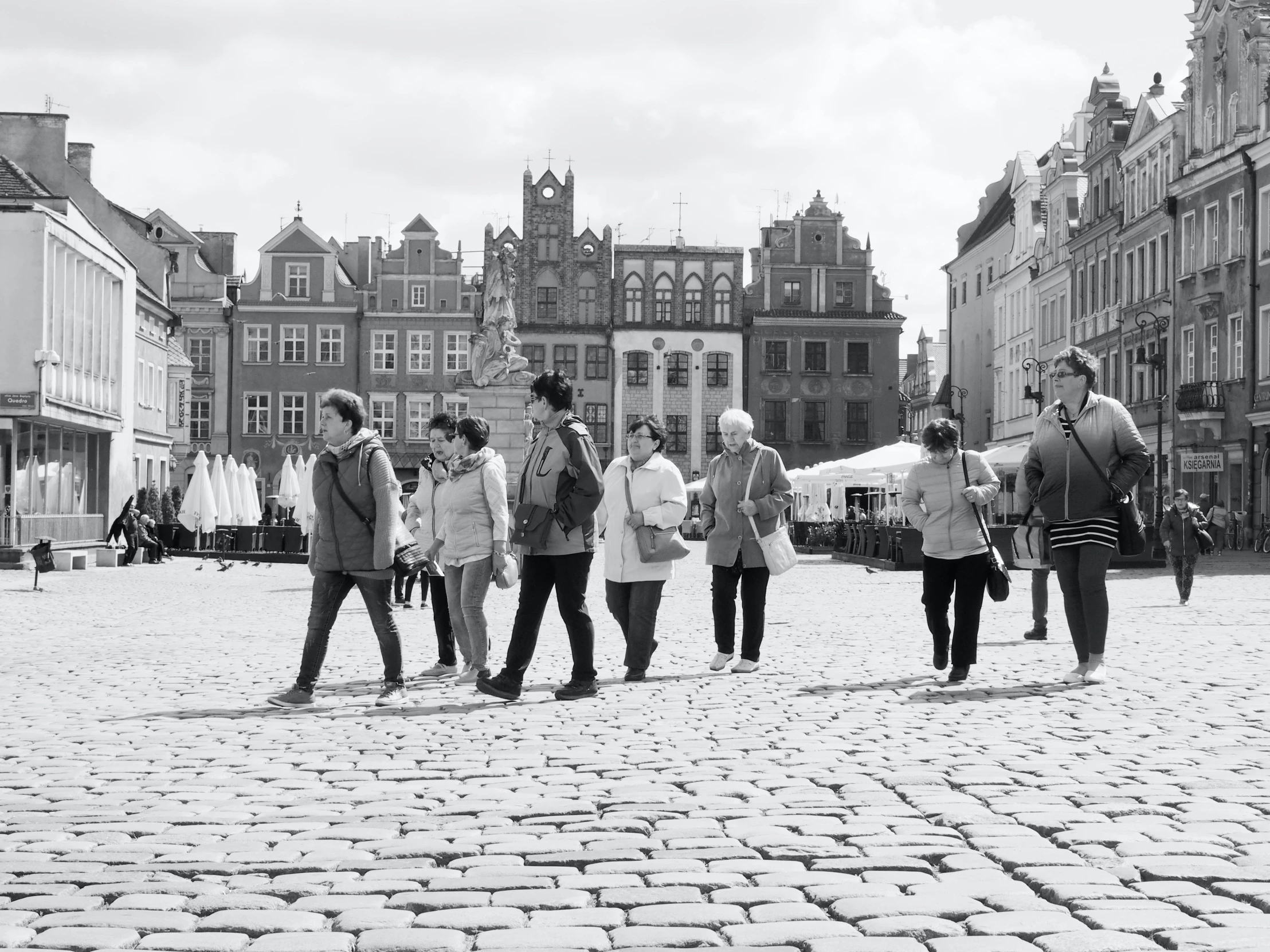 people walk through the street near buildings in an old city