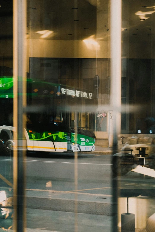 a bus in the city is reflected in the window