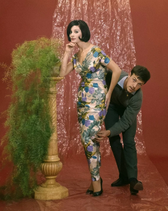 a woman and a man posing in front of a decorative object