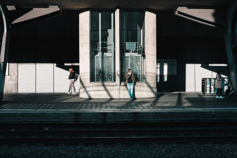 a couple standing on train tracks next to an entrance