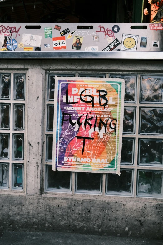 a graffiti - covered sign hanging on the wall of a building