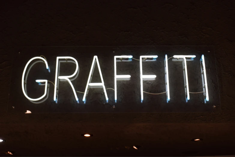 a large neon sign is shown against a dark wall