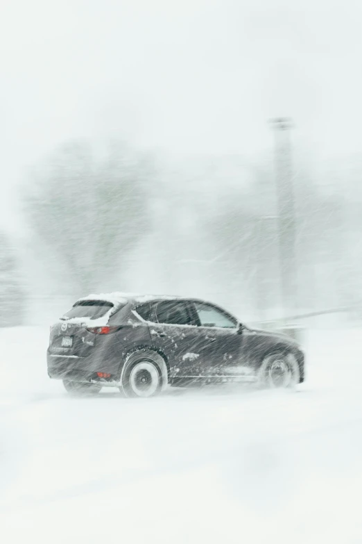 the back end of a car driving down a snow covered road