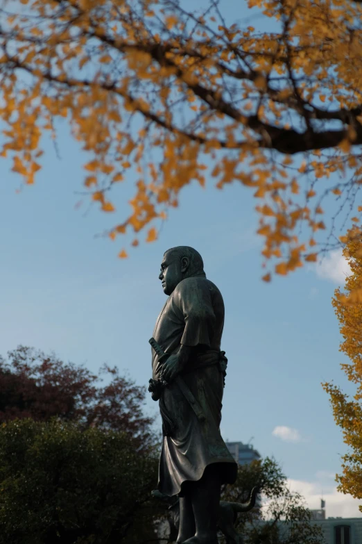 a tall statue sitting on the side of a hill next to some trees