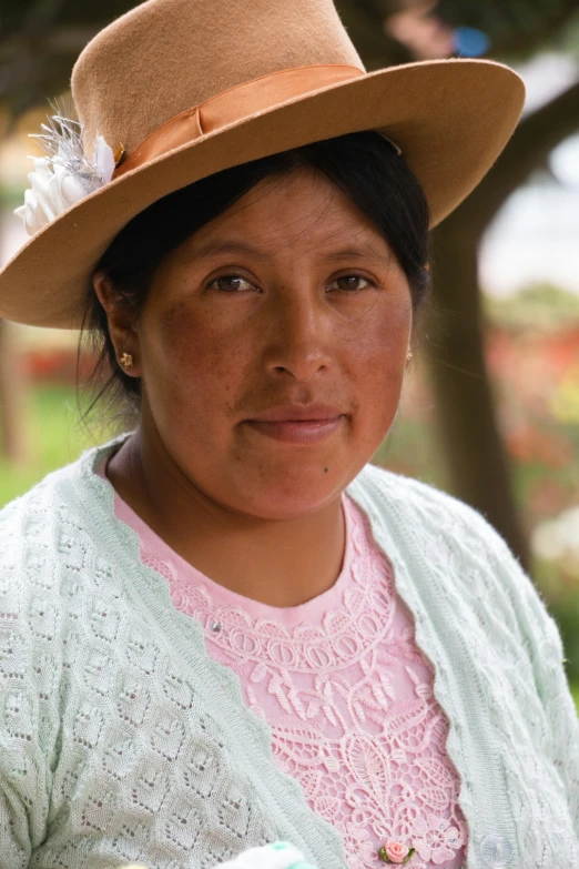 a woman wearing a hat looking at the camera