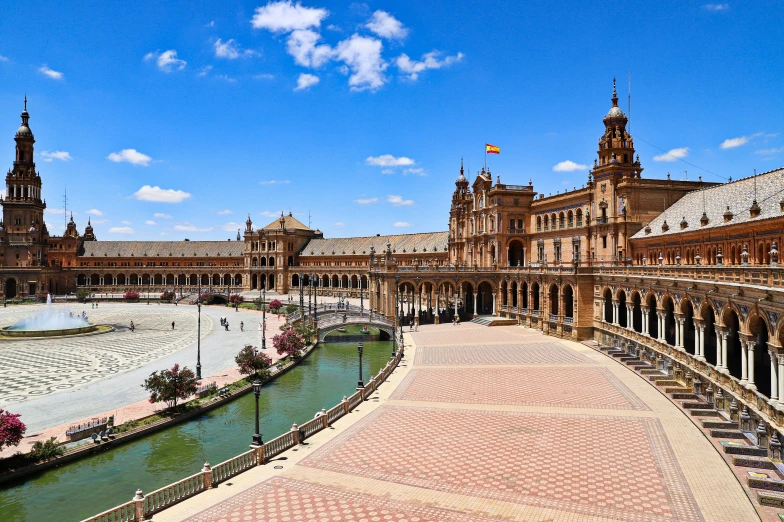 a walkway with fountain in front and a large building with towers