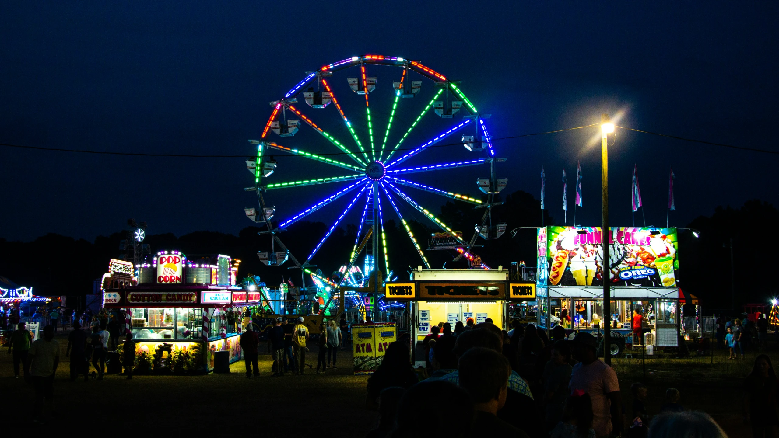 colorful lights shine on a fairground at night