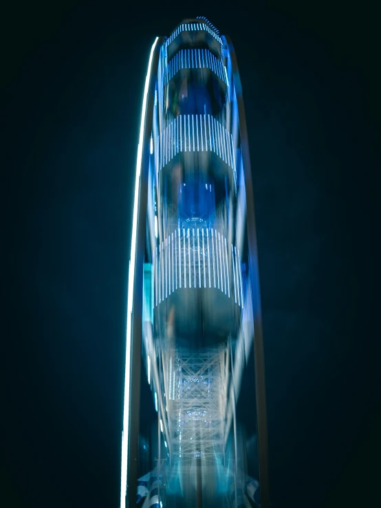 a tall ferris wheel with a blue light at the top