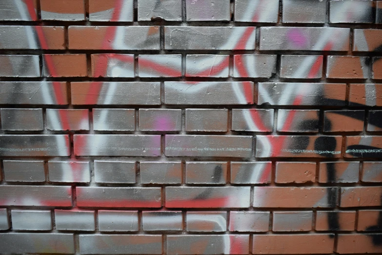 graffiti is on a brick wall that shows the same way