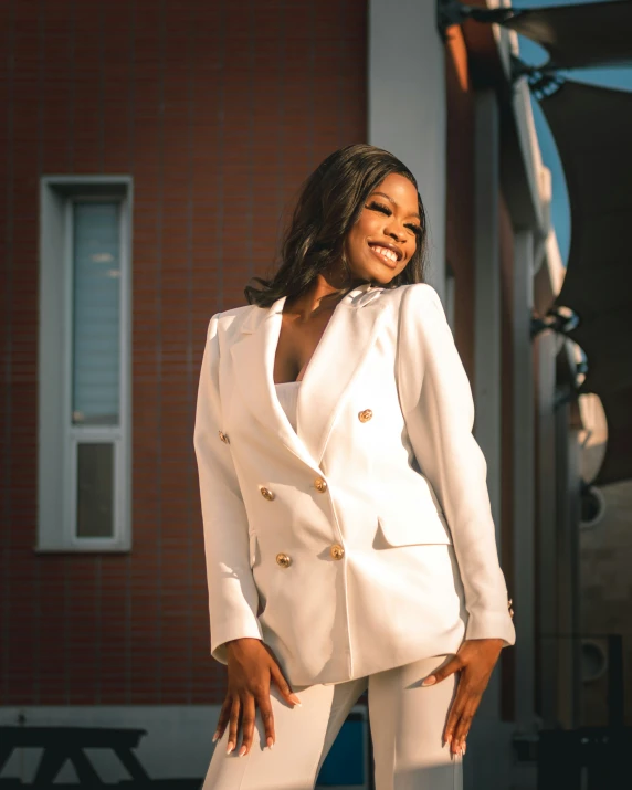 a smiling woman in white clothing standing outside