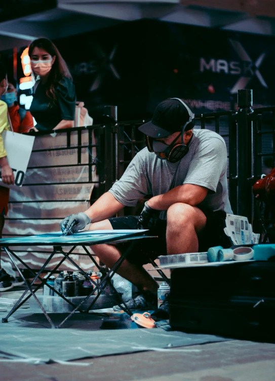 a man on the street repairing a piece of equipment