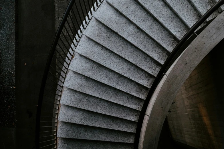 spiral staircase in dark room with light from above