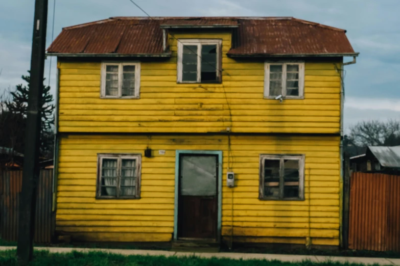 a yellow building with a brown roof