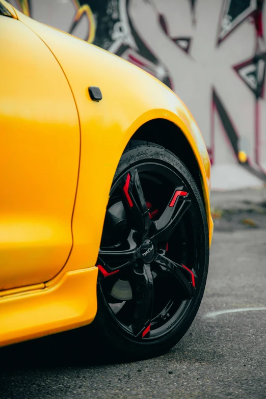 the yellow sports car is parked on the concrete