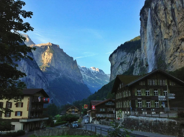 a very tall mountain behind some buildings and trees