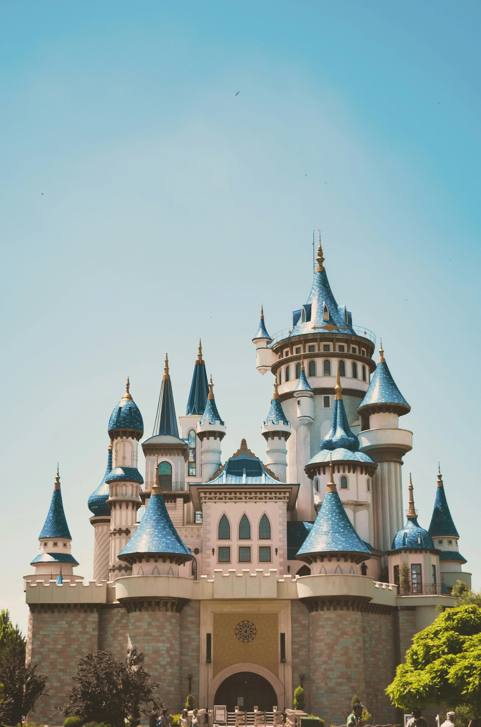 a big building with many blue domes near trees