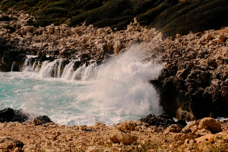 water comes out of the rocks into the blue ocean