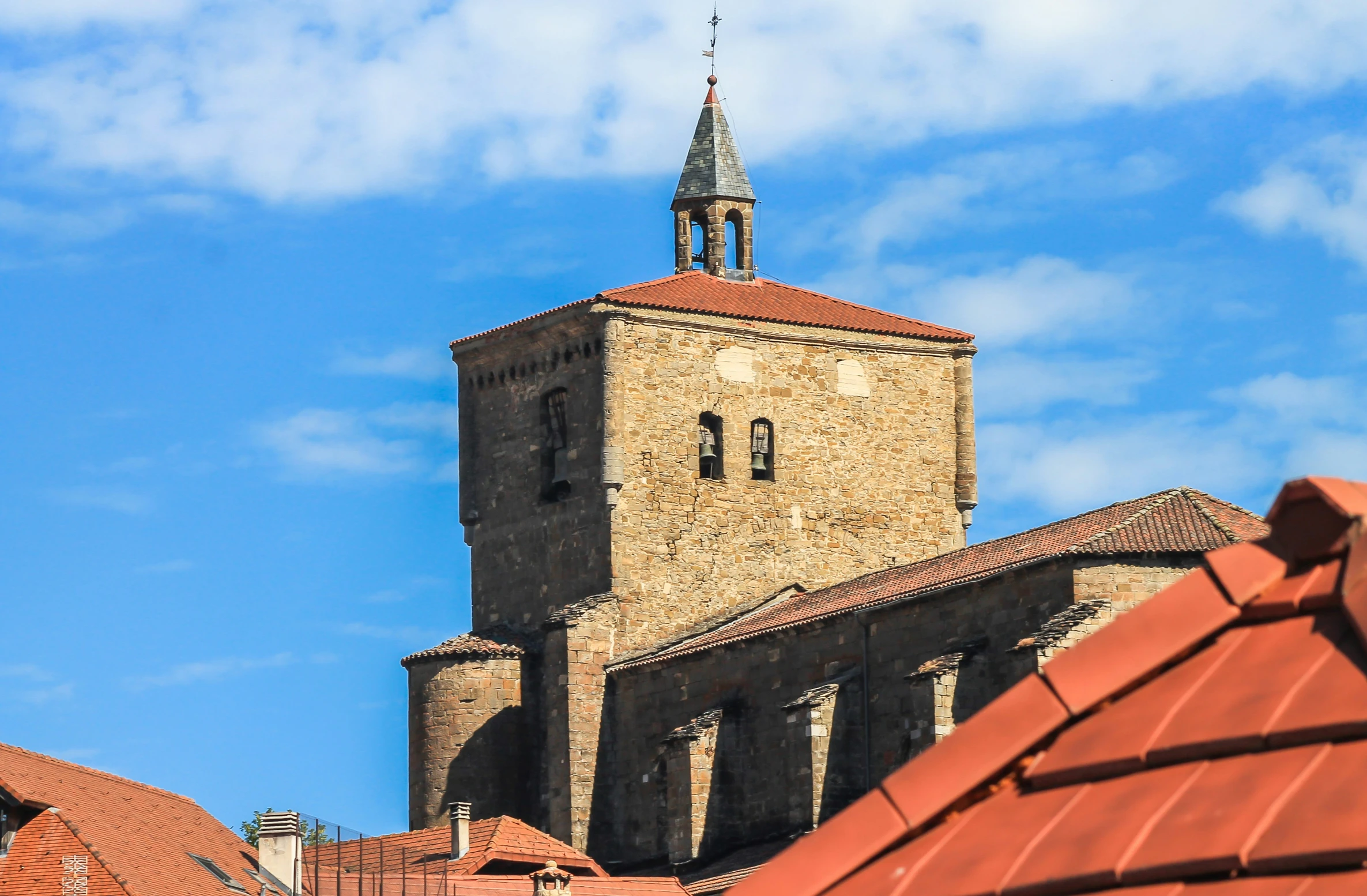 view of an old building in the foreground and a steeple on the right