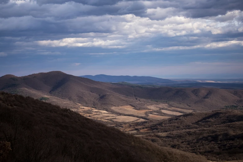 a landscape view of hills, with some clouds in the background