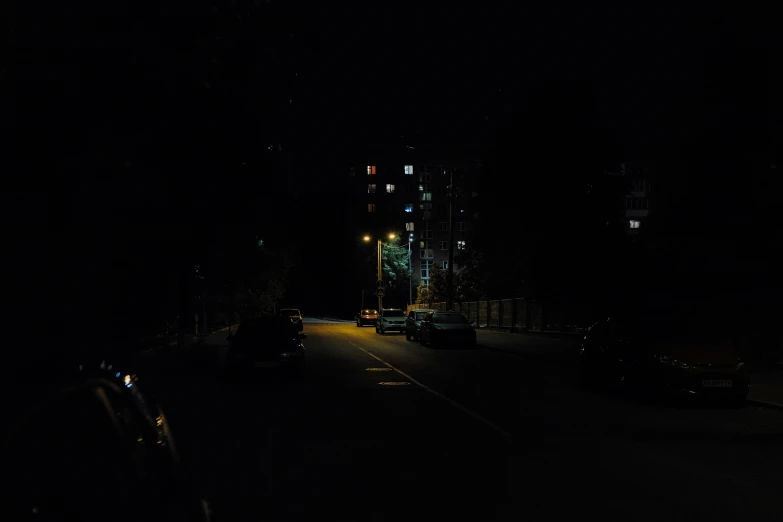 a dark street at night with traffic lights on