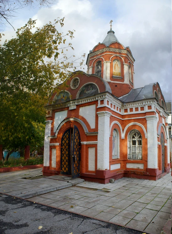 a white and orange building on pavement next to trees