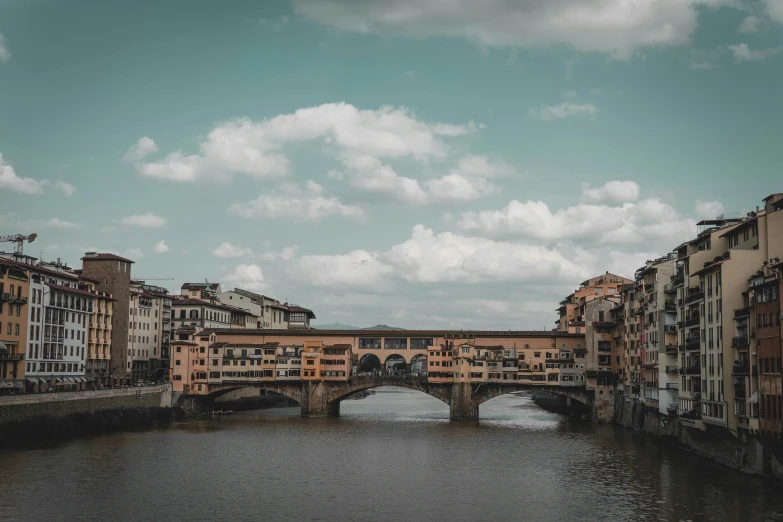 an old bridge is above a river in europe